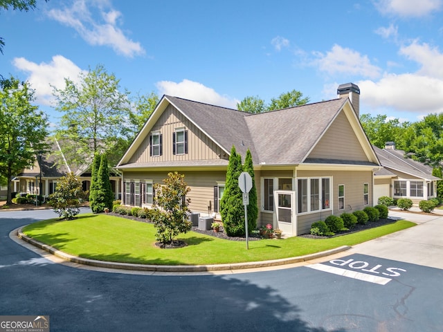 craftsman inspired home with a front lawn and central AC