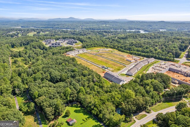 drone / aerial view featuring a wooded view and a mountain view