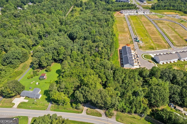 birds eye view of property featuring a view of trees