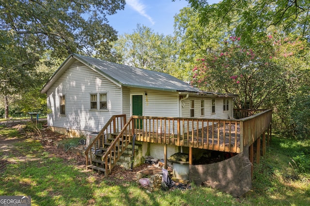 rear view of house featuring a deck and metal roof