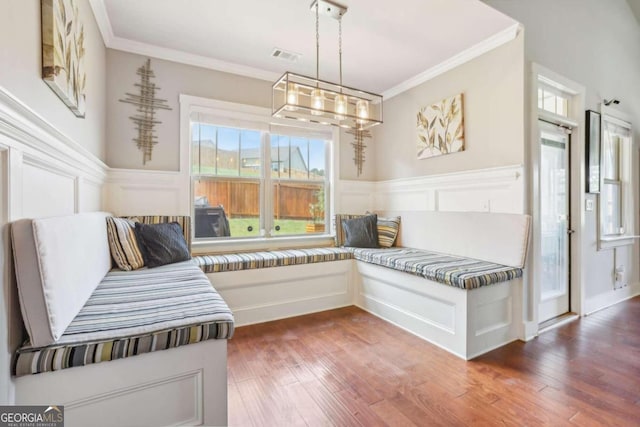 living area with dark hardwood / wood-style flooring, ornamental molding, and a notable chandelier