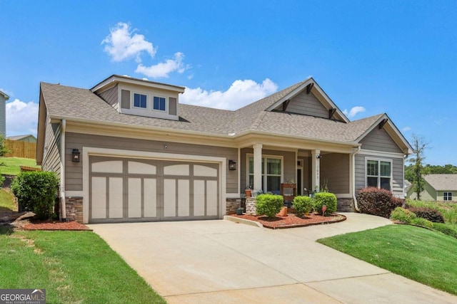 craftsman inspired home with a front lawn, covered porch, and a garage