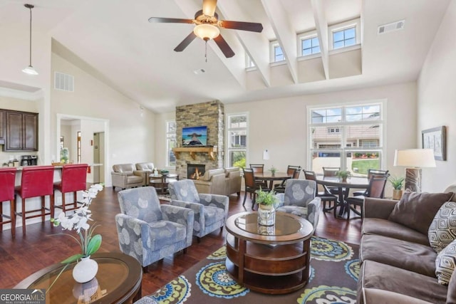 living room with ceiling fan, a fireplace, high vaulted ceiling, and dark wood-type flooring