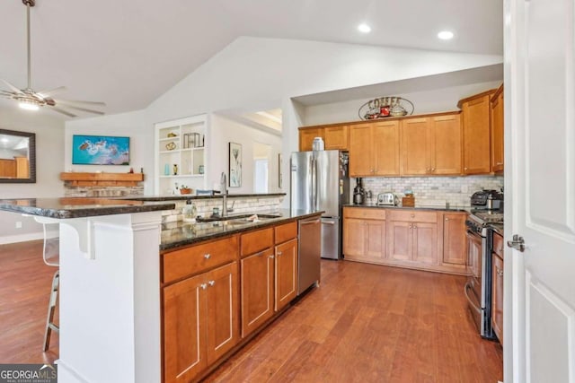 kitchen with a kitchen breakfast bar, backsplash, vaulted ceiling, and a kitchen island with sink