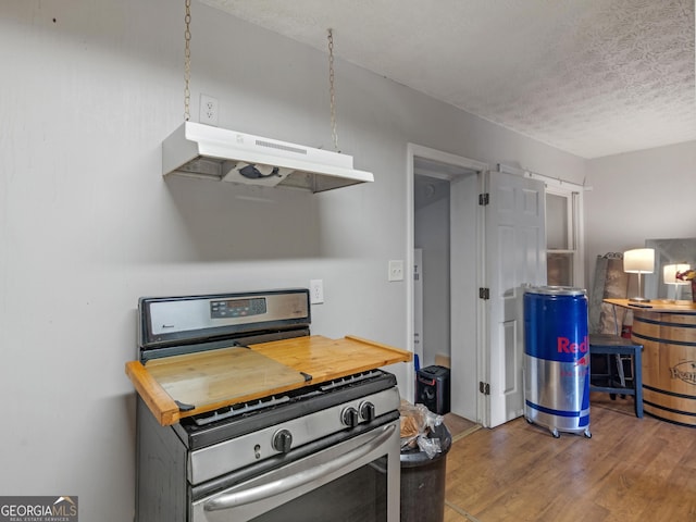 kitchen featuring wood-type flooring, a textured ceiling, and stainless steel gas stove