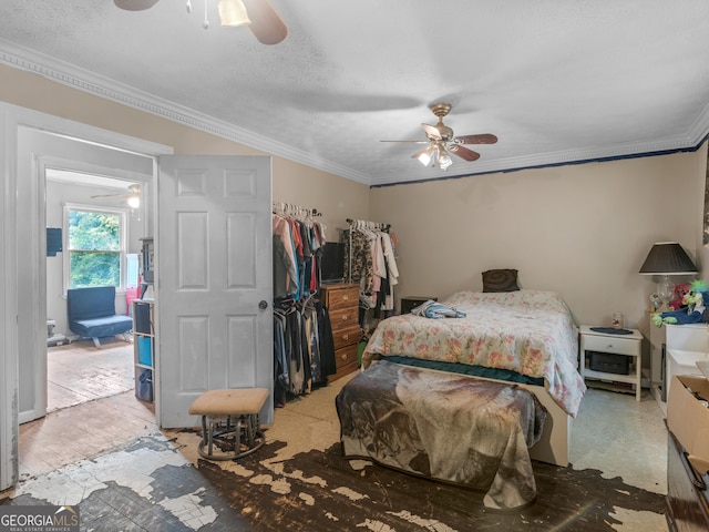 bedroom with ceiling fan, ornamental molding, and a textured ceiling