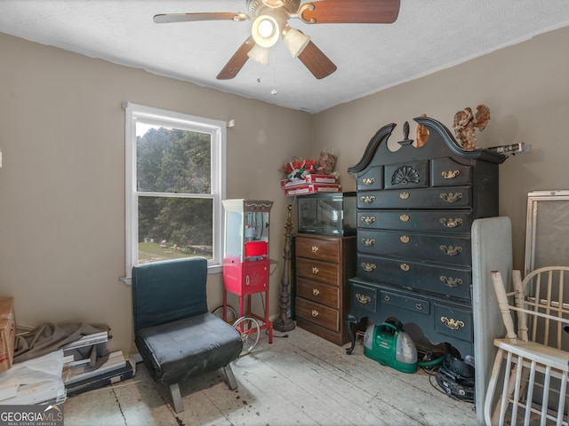 sitting room featuring ceiling fan and a textured ceiling