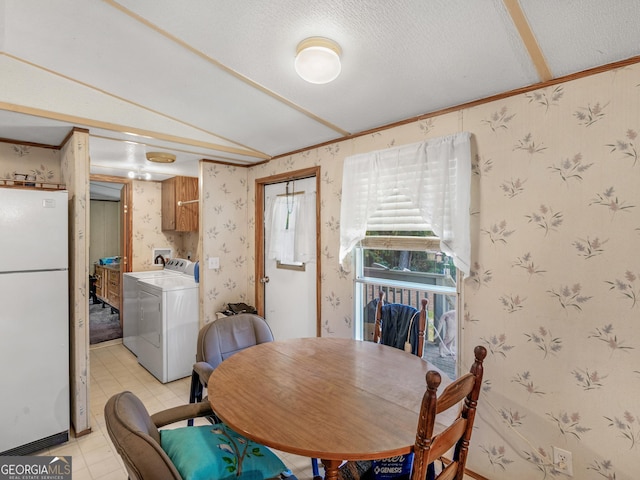 dining room featuring washer / clothes dryer, vaulted ceiling, ornamental molding, and a textured ceiling