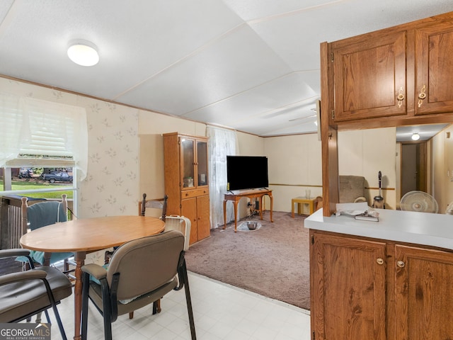 carpeted dining room with vaulted ceiling