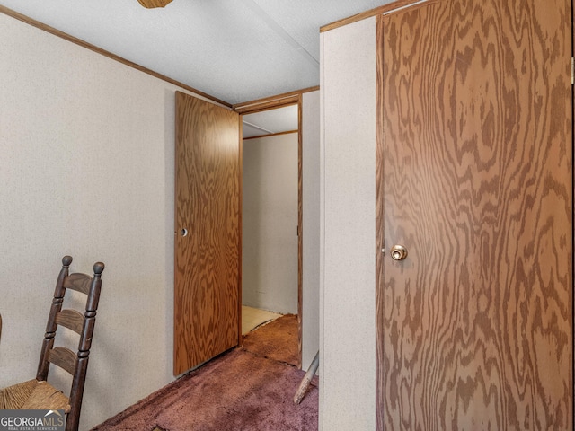 hall featuring ornamental molding and carpet