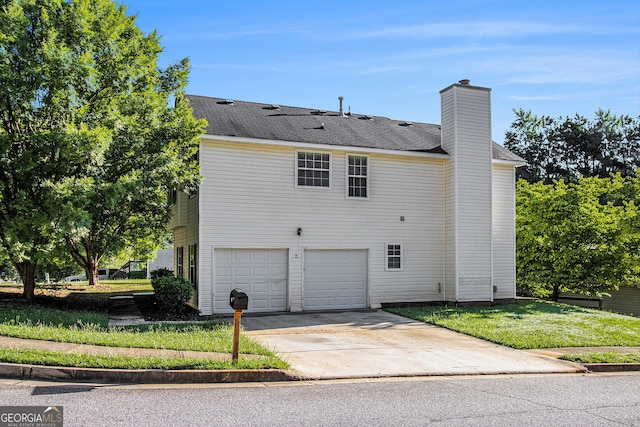 view of side of home with a garage and a lawn