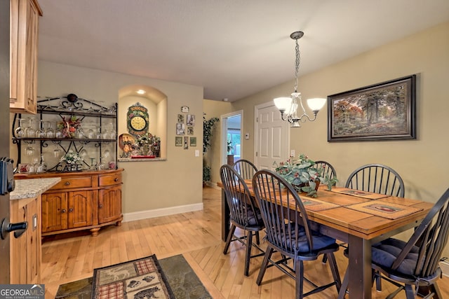 dining room featuring a notable chandelier and light hardwood / wood-style flooring