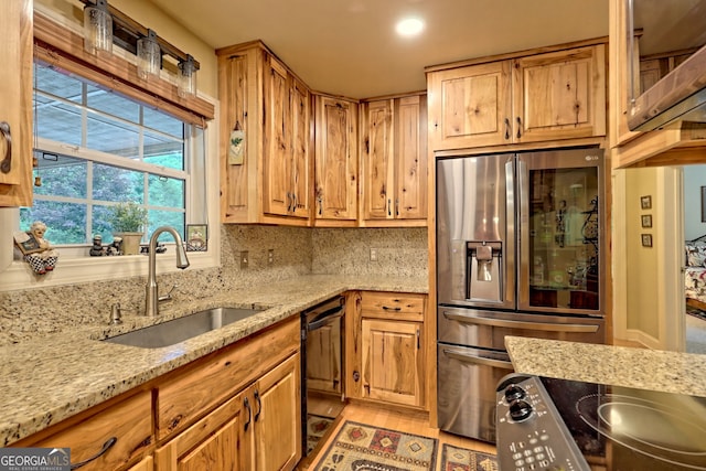 kitchen featuring sink, backsplash, light stone countertops, stainless steel fridge with ice dispenser, and dishwasher