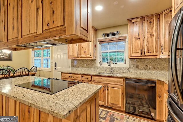 kitchen with sink, black appliances, light stone countertops, and backsplash