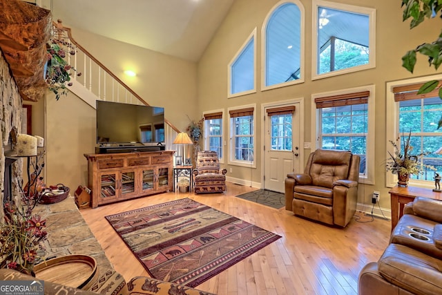 living room with high vaulted ceiling and wood-type flooring