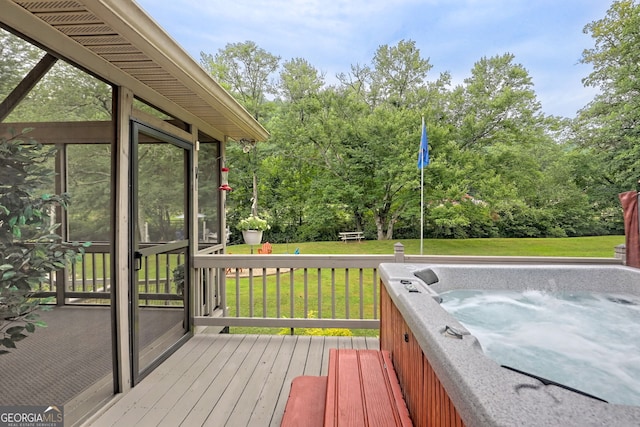 deck featuring a lawn, a hot tub, and a sunroom