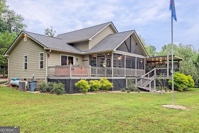 rear view of house featuring cooling unit, a sunroom, a yard, and a wooden deck