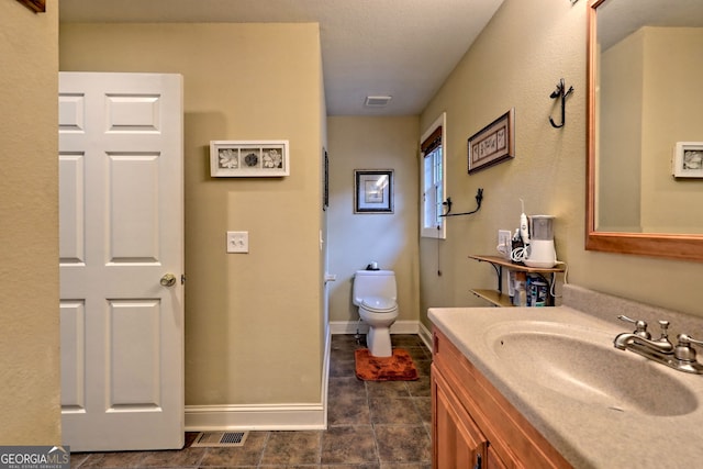 bathroom with vanity, toilet, and tile patterned floors