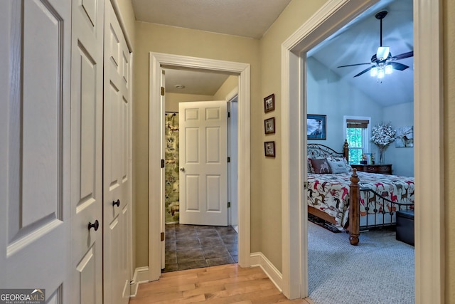 corridor with carpet and vaulted ceiling