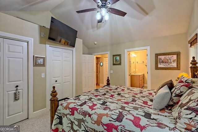 bedroom with lofted ceiling, ceiling fan, light colored carpet, multiple closets, and ensuite bath