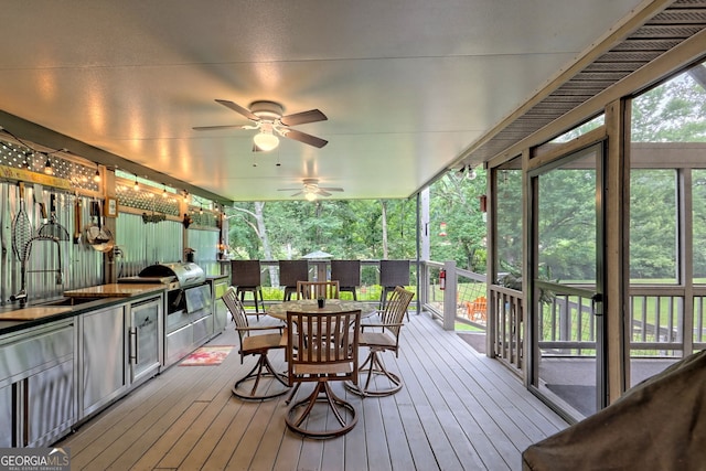 wooden deck featuring sink, ceiling fan, and an outdoor kitchen