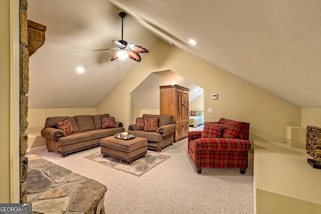 carpeted living room with ceiling fan and vaulted ceiling