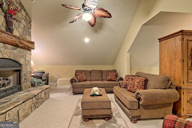 carpeted living room with lofted ceiling, a stone fireplace, and ceiling fan