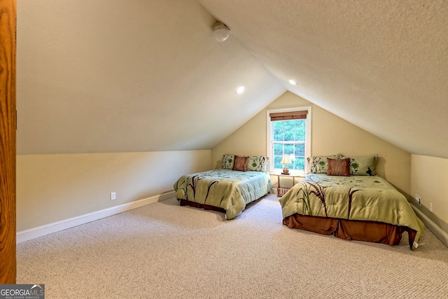 carpeted bedroom featuring a textured ceiling and vaulted ceiling