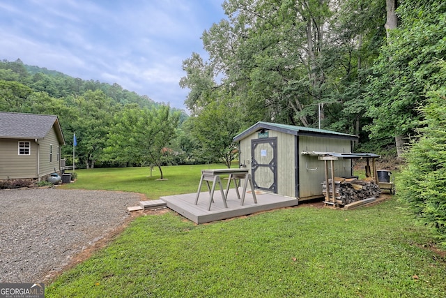 view of yard featuring a wooden deck and a storage shed