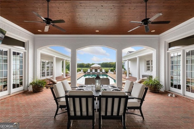 sunroom / solarium with ceiling fan, wood ceiling, and a healthy amount of sunlight