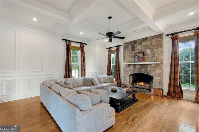 living room featuring ceiling fan, wood-type flooring, crown molding, and beamed ceiling