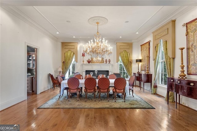 dining space with crown molding, a chandelier, and hardwood / wood-style flooring