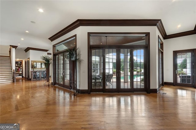 entryway featuring ornamental molding, french doors, and decorative columns