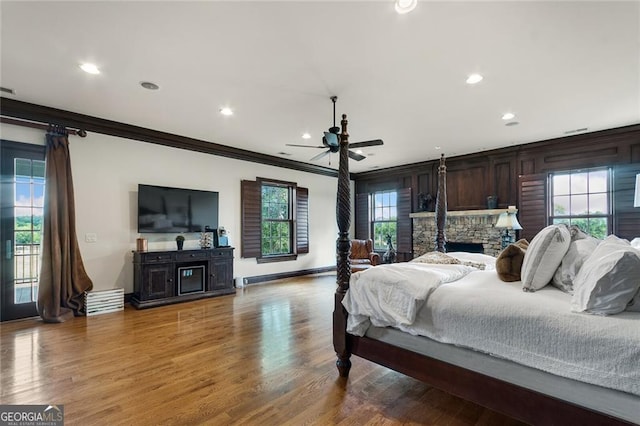 bedroom featuring multiple windows, hardwood / wood-style flooring, ornamental molding, access to outside, and ceiling fan