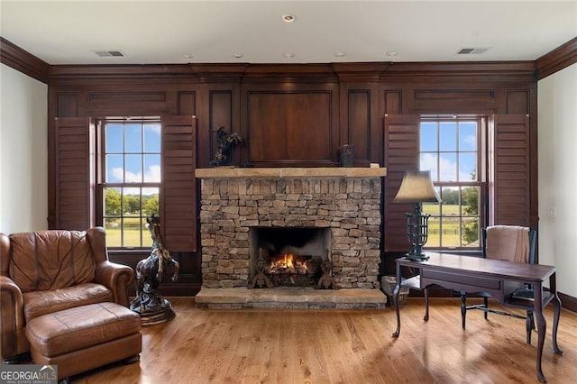 sitting room with light hardwood / wood-style floors, ornamental molding, and a fireplace