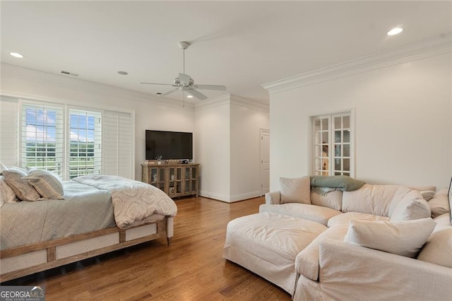 bedroom featuring ceiling fan, ornamental molding, and wood-type flooring