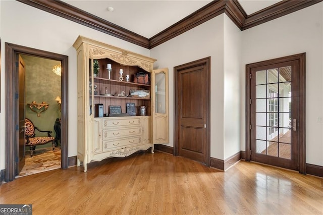 doorway with crown molding and light wood-type flooring