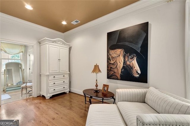 living area with ornamental molding and hardwood / wood-style flooring