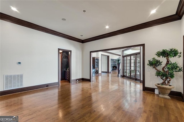 spare room with french doors, ornamental molding, and wood-type flooring