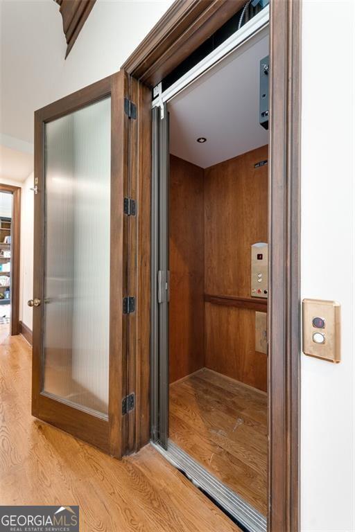 bathroom with wood-type flooring and elevator