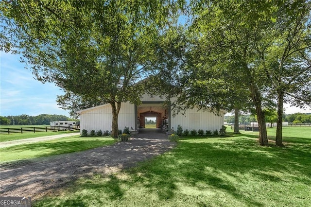 view of front of property featuring a front lawn and an outdoor structure