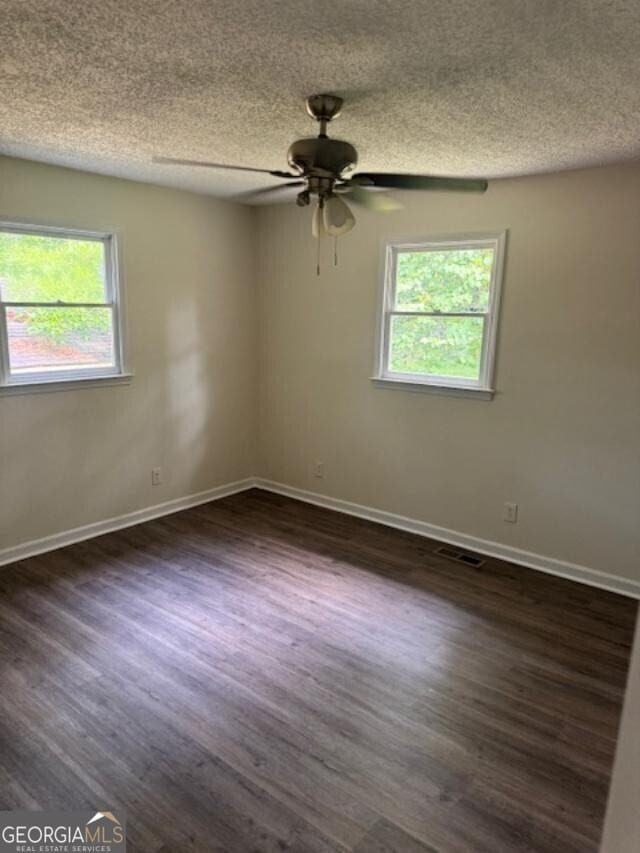 unfurnished room with a textured ceiling, ceiling fan, and dark hardwood / wood-style flooring