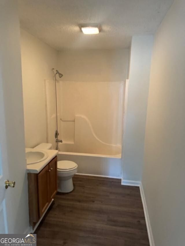 full bathroom with toilet, bathing tub / shower combination, hardwood / wood-style flooring, a textured ceiling, and vanity