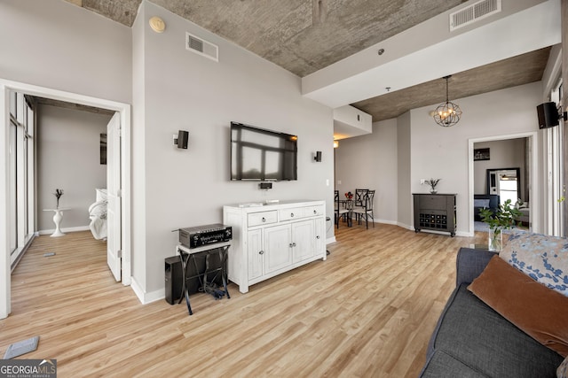 living room featuring a chandelier and light wood-type flooring