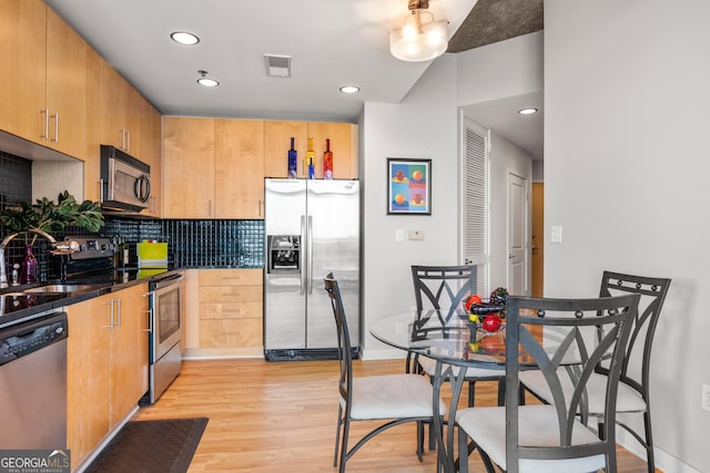 kitchen featuring light brown cabinetry, tasteful backsplash, sink, stainless steel appliances, and light hardwood / wood-style flooring