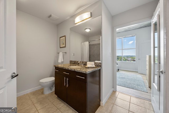 bathroom with tile patterned flooring, vanity, toilet, and walk in shower