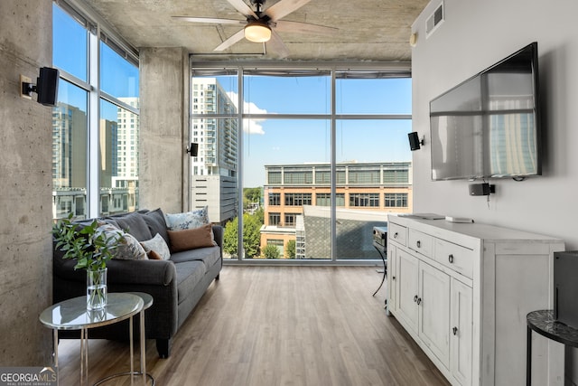 interior space featuring ceiling fan, floor to ceiling windows, and light hardwood / wood-style floors