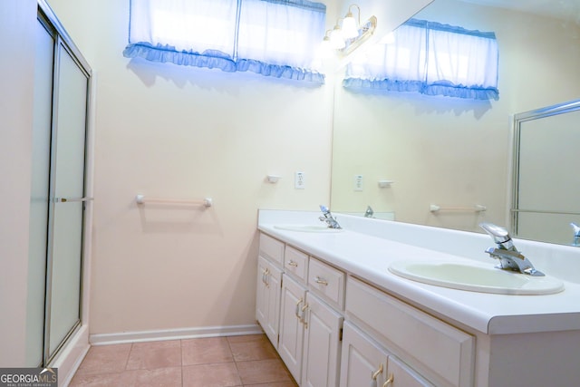 bathroom with vanity, tile patterned flooring, a healthy amount of sunlight, and walk in shower