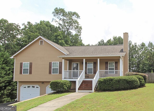 view of front of property featuring a porch, a garage, and a front lawn