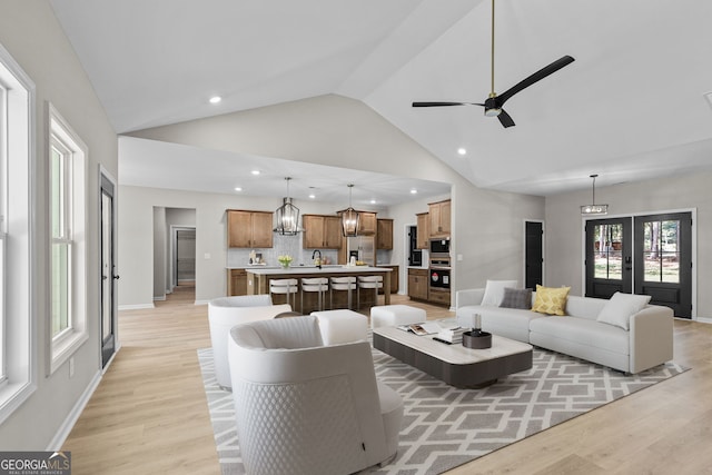 living room featuring french doors, high vaulted ceiling, light wood-type flooring, and ceiling fan